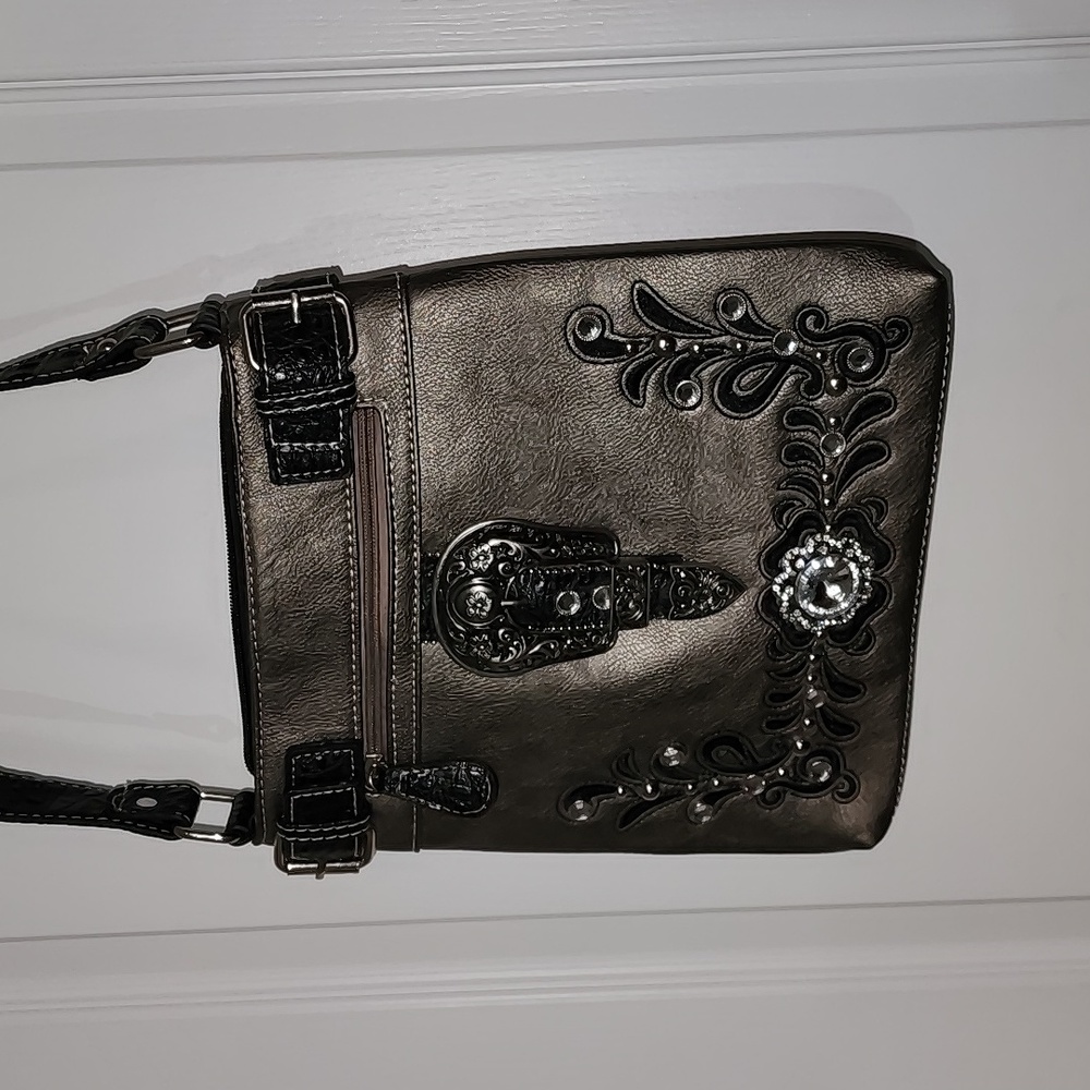 Womens western style purse with rhinestone and buckle embellishments.